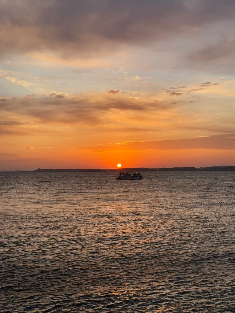 Lever de soleil sur le lac Nasser devant le temple d'Abou Simbel dans des couleurs intenses et orangées.