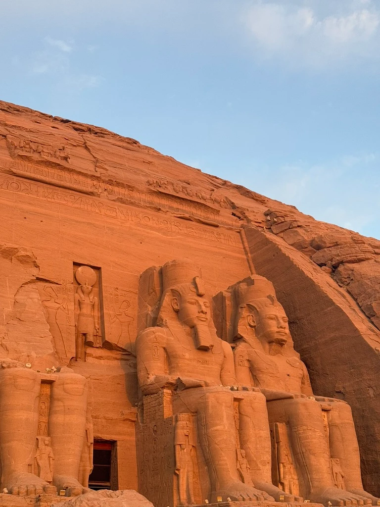 Lever du soleil sur le temple d'Abou Simbel le parant d'une lumière orangée