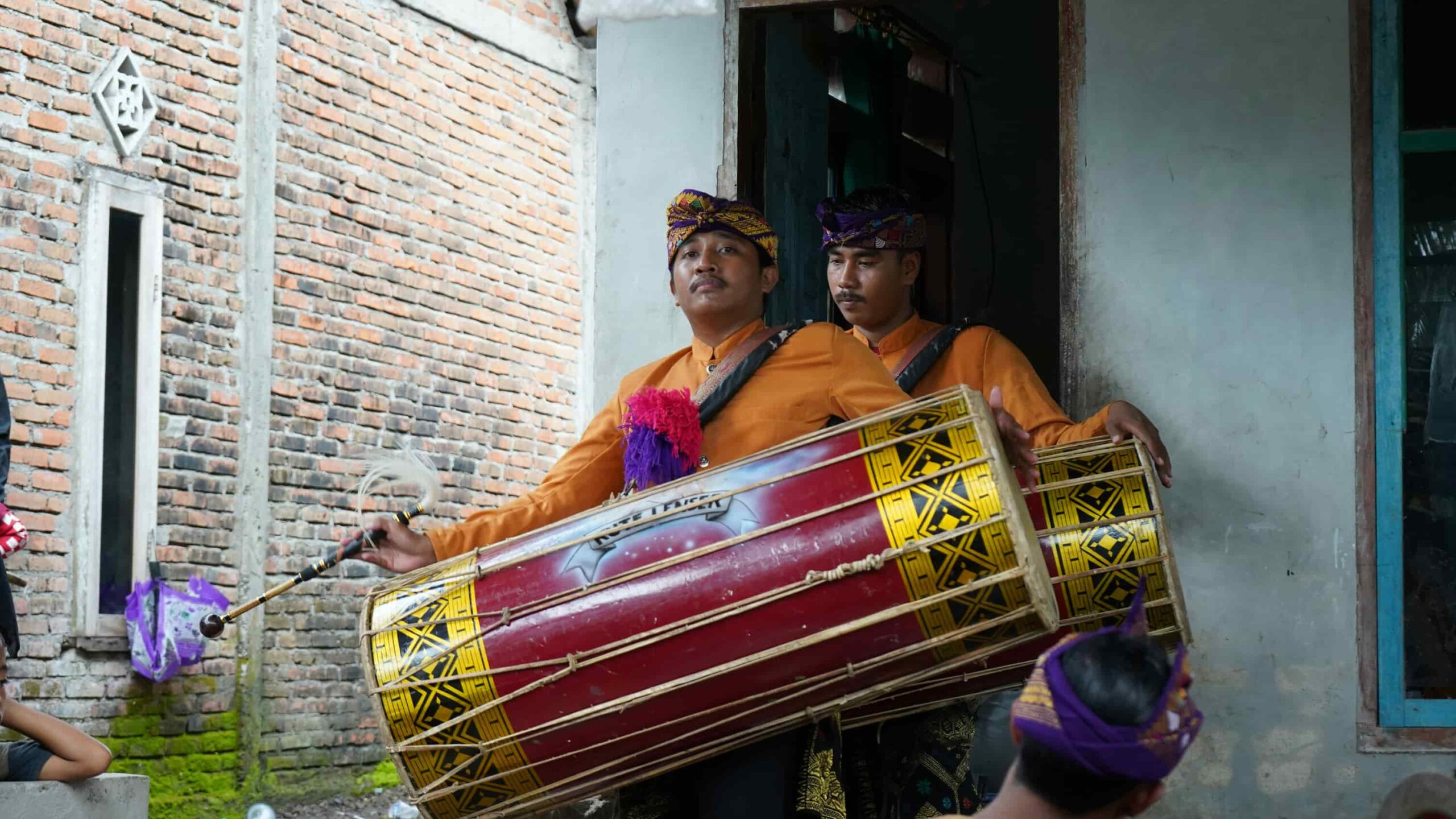 Deux hommes portants des tambours et habillés en vêtements traditionnels Sasak