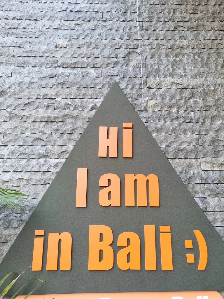 Panneau triangulaire Hi, I am in Bali avec un smiley et une écriture orange