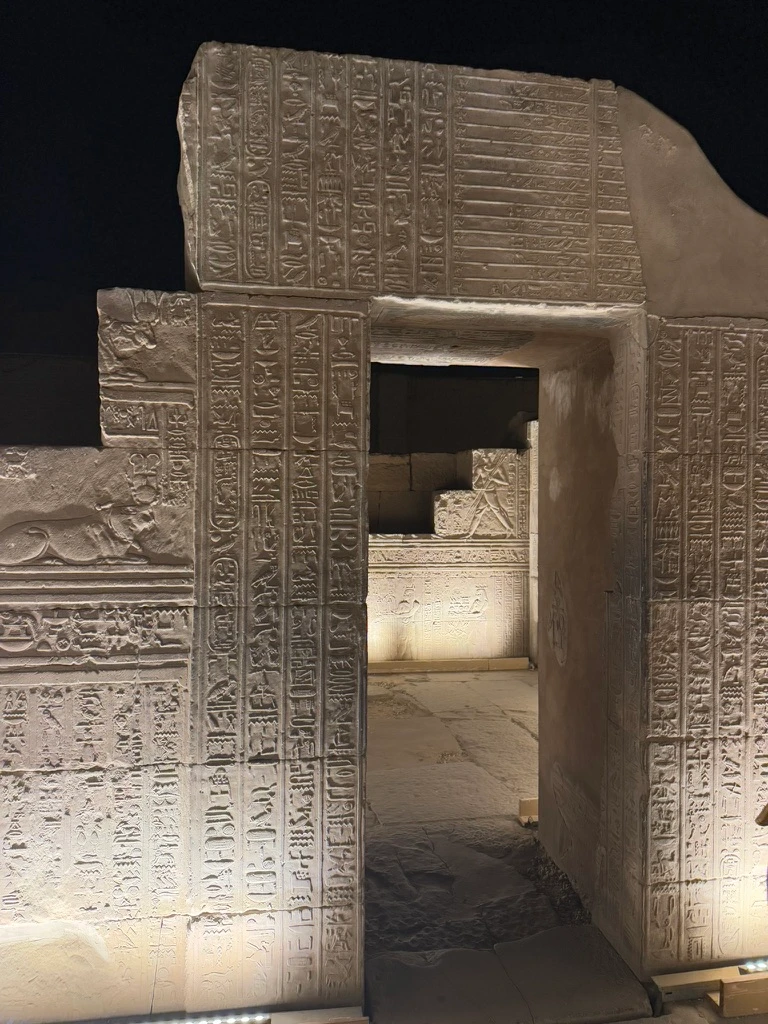 Porte du temple de Kom Ombo, de nuit avec un rétroéclairage mettant en valeur les détails des gravures