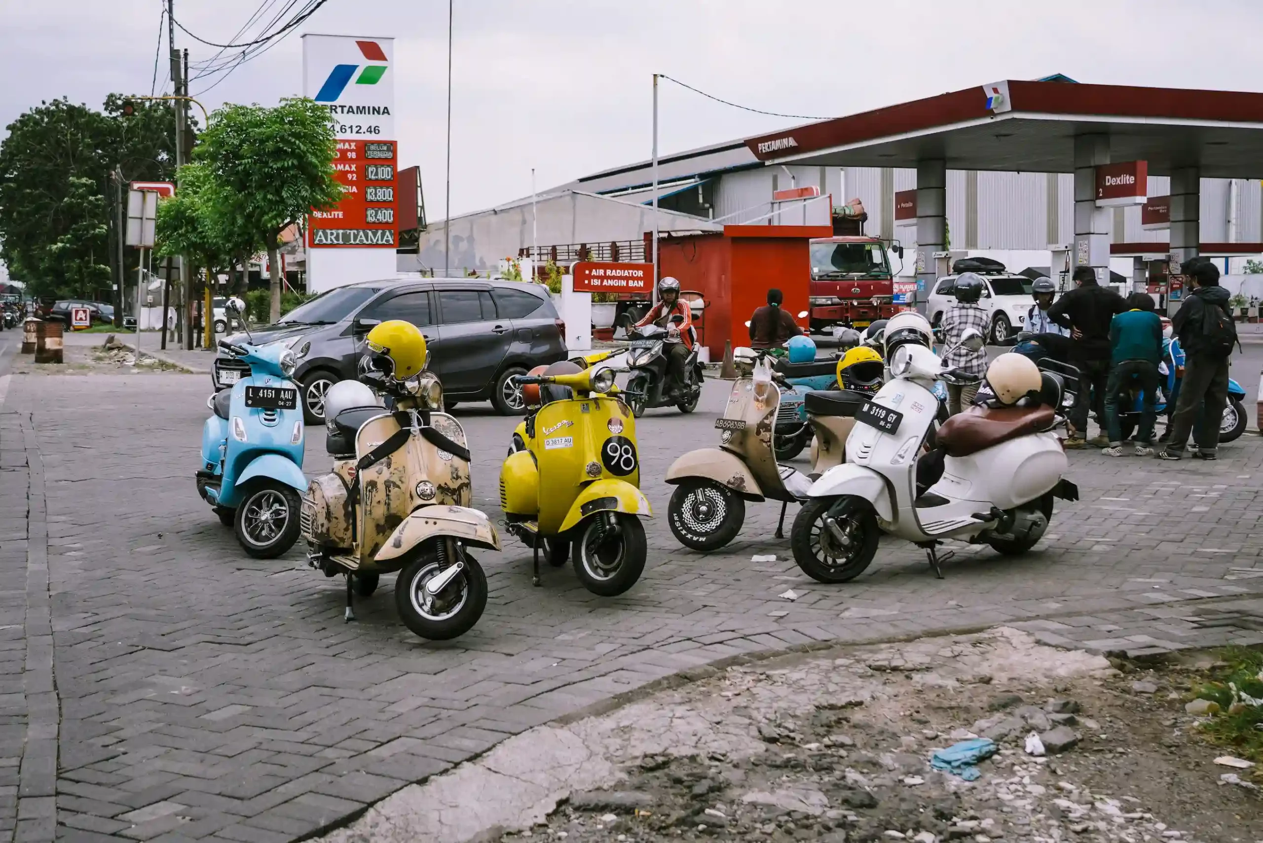 Plusieurs scooters devant une station essence 