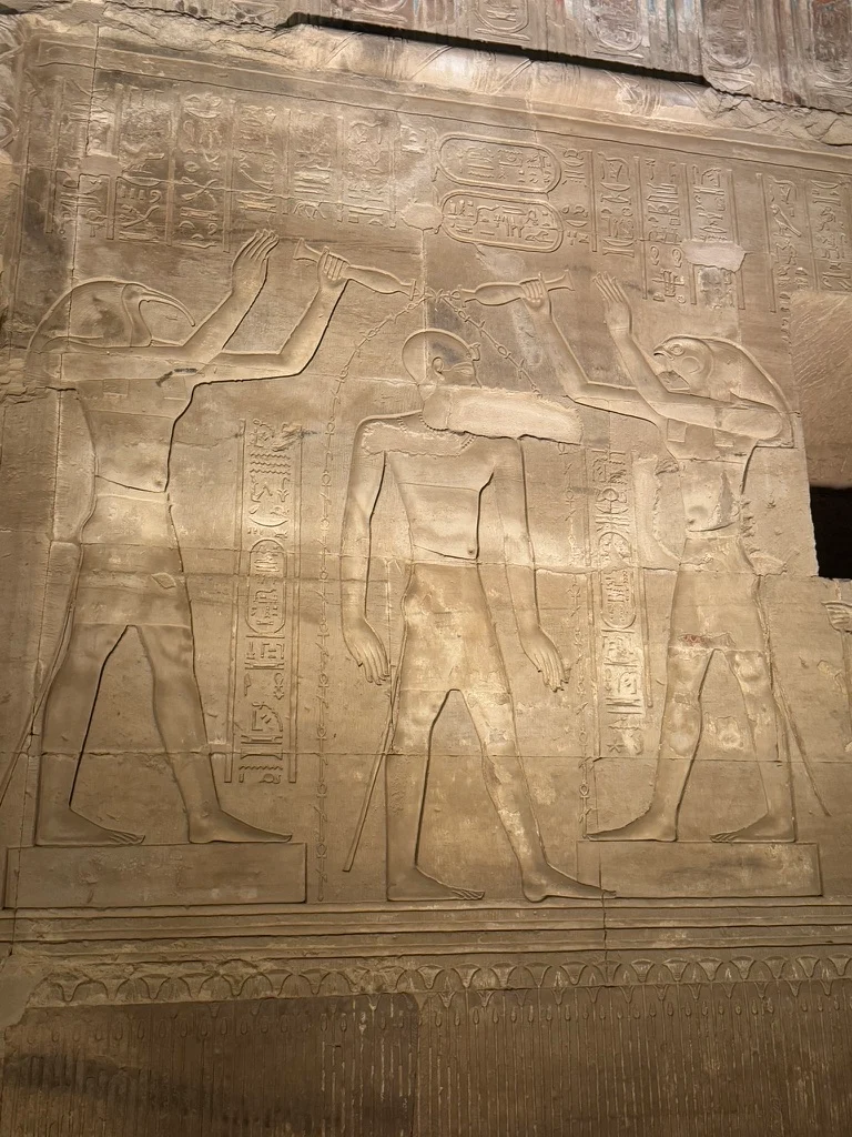 Scène gravée sur le temple de Kom Ombo, à la lueur des lumières dans la nuit