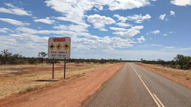 Route infinie avec panneau "attention animaux sur le cote gauche"