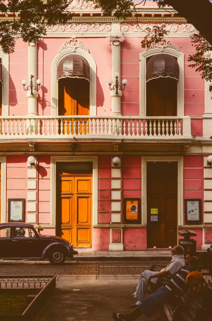 Mérida, capitale du yucatan avec une facade rose et des voitures garées devant